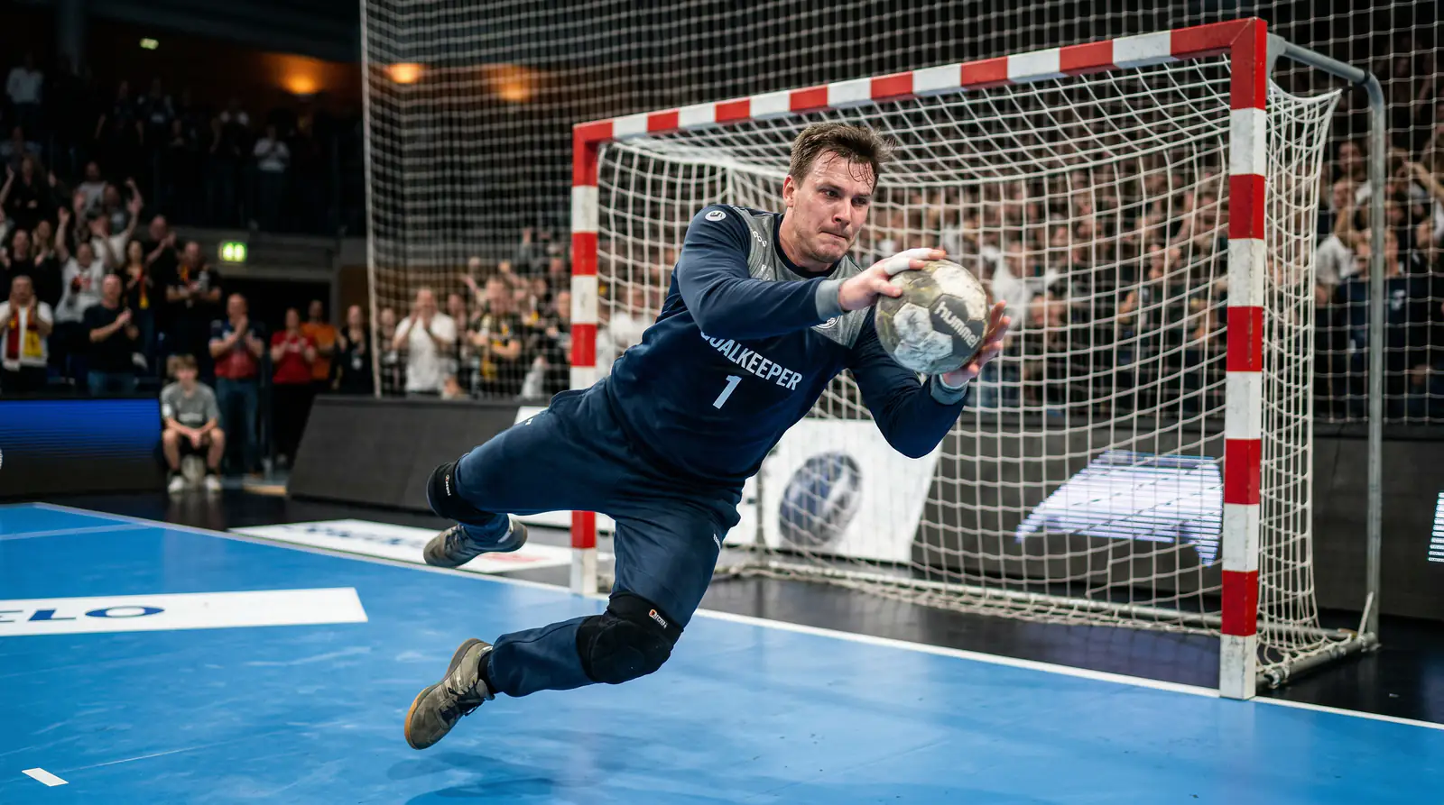 Handball-Torhüter hält einen Wurf im Spiel ab